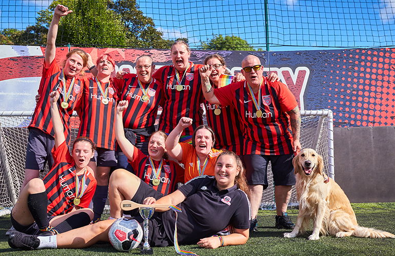 7 a-side team pose after thier match, plus the golden retriever 